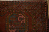 Vintage Ersari rug corner showing geometric guls, detailed charcoal borders, and aged texture.