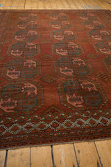 Distressed Ersari carpet's geometric border with plant motifs and chestnut red guls.