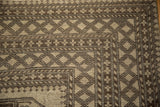 Ersari rug corner with distressed geometric diamond and snowflake motifs in beige and chocolate brown.