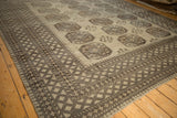 Vintage Ersari carpet's distressed pile, geometric diamond borders, and central gul patterns.