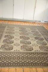 Distressed Ersari carpet detail: geometric gul, snowflake blossom, and pawn motifs in neutral tones.
