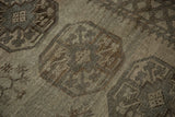Textured distressed Ersari carpet detail, featuring geometric gul motifs and muted beige, silver-brown shades.