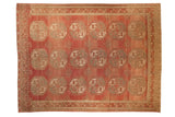 Vintage distressed Ersari carpet with hexagonal gul medallions across an abrashed raspberry red field.