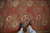 A person's view of the distressed, low-pile texture of the vintage Ersari carpet.