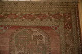 Intricate geometric border of a vintage Ersari carpet in time-softened red and brown shades.