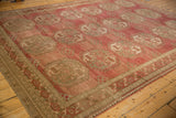 Angled view of a distressed Ersari carpet, showing the texture of the abrashed red pile and geometric guls.