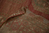 Folded corner of a distressed Ersari carpet revealing the hand-knotted foundation and side cord.