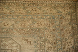 Distressed vintage Ersari rug corner showing geometric patterns and soft blue-beige palette.