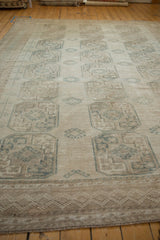 Distressed Ersari carpet with even wear, featuring faded ivory and dusty teal gul medallions.