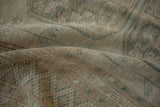 Distressed vintage Ersari carpet, highlighting worn pile texture and dusty teal geometric motifs.