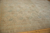 Distressed Oushak rug showing geometric border pattern and faded teal gul medallions.