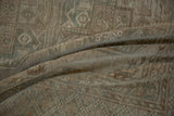 Textural close-up of distressed Oushak carpet, showing worn pile with muted beige and faint teal.