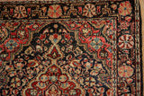 Corner detail of a vintage Josan Sarouk rug showing its pinwheel vine border and floral spandrel.