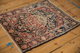 A vintage Josan Sarouk rug with its scalloped medallion, navy blue field, and floral borders.