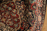 Angled detail of a vintage Josan Sarouk's lustrous wool pile and brick red floral motifs.