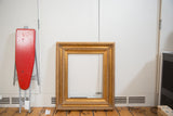 Vintage golden wood picture frame's upper right corner, with ornate carved details.
