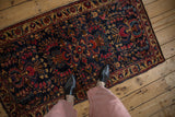 A person's view looking down at an antique Mohajeran Sarouk runner showing its scale and deep indigo field.