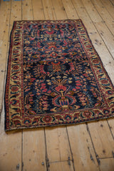 Angled view of an antique Mohajeran Sarouk runner showing its deep blue field and ivory floral border.