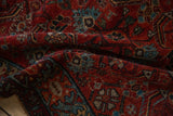 Softly folded vintage Hamadan rug showing the texture of its low pile and gem-like tones.