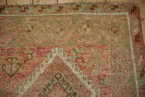Close-up of a distressed Kurdish rug showing even wear to the knot heads and geometric border.