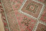 Evenly worn texture of a vintage Kurdish rug with geometric guls in blush and muted green.