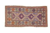 Faded vintage Oushak rug, aubergine stepped medallions, terracotta pinwheel floral borders.