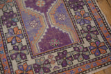 Visible wear and aubergine, terracotta, ivory geometric pinwheel blossoms on the vintage Oushak rug.