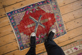 Distressed Oushak pile with mostly even wear, cherry red, blue, fuchsia starburst pattern.