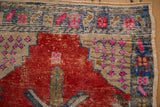 Oushak rug corner detail with cherry red, fuchsia, blue geometric patterns, showing even wear.