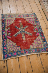 Distressed Oushak rug corner with cherry red field, fuchsia geometric spandrel, sapphire blue border.
