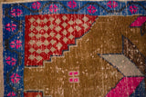 Distressed vintage Oushak rug with sapphire border, magenta blooms, and red geometric pattern.