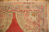 Evenly worn corner spandrel and border of a vintage Oushak rug in slate blue and raspberry.