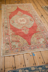 A distressed vintage Oushak runner with a slate blue roundel medallion, seen from a full-length angle.
