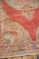 Corner spandrel detail of a distressed Oushak rug in slate blue, ivory, and dusty raspberry red.