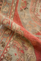 A soft fold across the distressed Oushak runner shows its even, low-pile texture.
