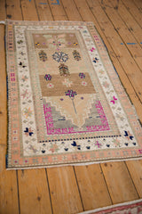 Striking magenta geometric motifs on the distressed vintage Oushak rug's faded ochre field.
