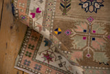 Vintage distressed Oushak rug's textured pile, rolled edge, and geometric motifs with magenta accents.