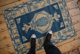 Distressed vintage Oushak rug with blue and beige hexagonal medallion and serrated patterns.