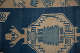 Distressed Oushak rug's serrated geometric pattern in dusty sapphire blue and ivory tones.