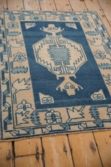 Distressed fringe and geometric border of a vintage Oushak rug, dusty sapphire blue and ivory.