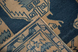Vintage distressed Oushak rug corner showing dusty sapphire blue geometric motifs and side cording.