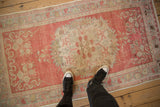 Overhead perspective of a distressed Oushak rug, showing its scale and soft blush pink and ivory tones.