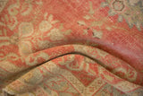 Soft, low pile with even wear on a folded vintage distressed Oushak rug in blush pink.