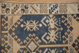 Vintage distressed Oushak rug close-up: geometric blue and beige hook and latch motifs.