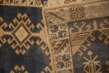 Distressed vintage Oushak rug corner showing geometric pile, hand-knotted back, and selvage.