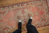 Distressed vintage Oushak runner with faded blush field and pale seafoam geometric border.