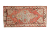 Vintage distressed Oushak rug runner with a shield-like medallion in dusty blush, pale slate, and brown.