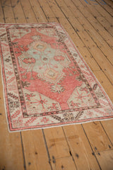 Vintage Turkish Oushak runner's full length and worn texture displayed from an angled perspective.