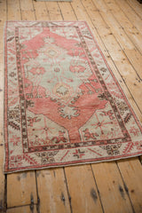 Angled view of a vintage Oushak runner with a shield-like medallion and soft, distressed texture.