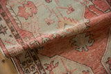 Visible hand-knotted weave and low pile of a distressed Oushak in blush and slate.